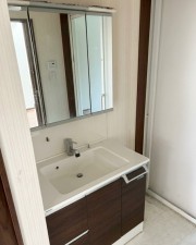 洗面室 【洗面室】3面鏡+シャワー水栓付きの洗面化粧台が設置されています。奥に洗濯機置き場があります。